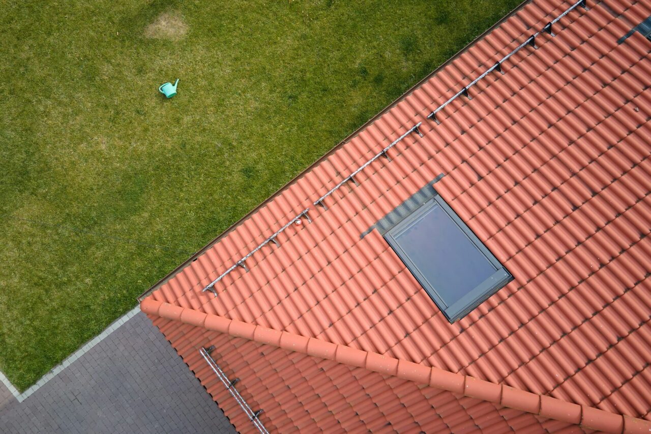 closeup-of-attic-window-on-house-roof-top-covered-with-ceramic-shingles-tiled-covering-of-building-e1726236573190.jpg